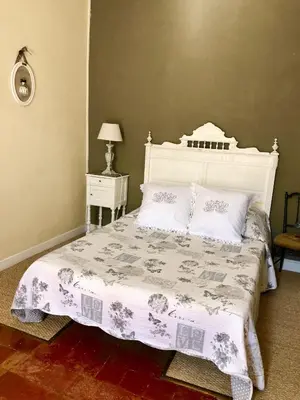 a bedroom with a white bed with a white headboard at Le Sillon d'Alaric in Lézignan-Corbières