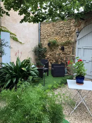 a garden with plants and a table and chairs at Le Sillon d'Alaric in Lézignan-Corbières