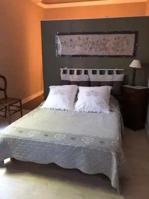 a bedroom with a large bed with white sheets and pillows at Le Sillon d'Alaric in Lézignan-Corbières