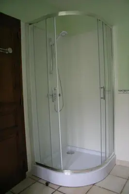 a shower with a glass door in a bathroom at Les Eaux Tranquilles in Belvianes-et-Cavirac
