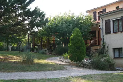 a house with a pine tree in front of a yard at Les Eaux Tranquilles in Belvianes-et-Cavirac