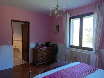 a bedroom with pink walls and a bed and a window at Les Eaux Tranquilles in Belvianes-et-Cavirac