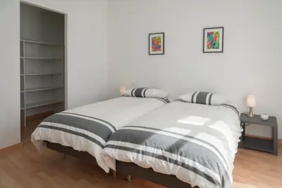 a bedroom with a bed with a black and white blanket at Maison Borrel in Carcassonne