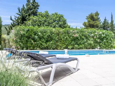 two lounge chairs sitting next to a swimming pool at Villa in Pouzols with Private Pool & Vineyards in Pouzols-Minervois