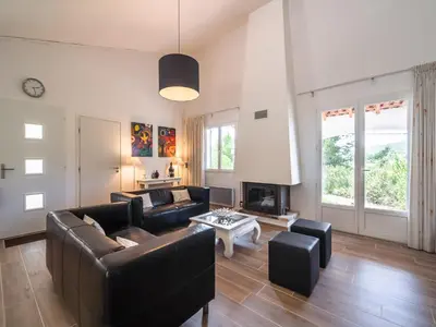 a living room with a couch and a fireplace at Villa in Pouzols with Private Pool & Vineyards in Pouzols-Minervois