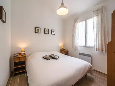 a bedroom with a white bed and a window at Villa in Pouzols with Private Pool & Vineyards in Pouzols-Minervois