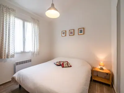 a bedroom with a white bed and a lamp on a table at Villa in Pouzols with Private Pool & Vineyards in Pouzols-Minervois