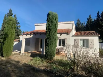 a white house with two trees in front of it at Villa in Pouzols with Private Pool & Vineyards in Pouzols-Minervois