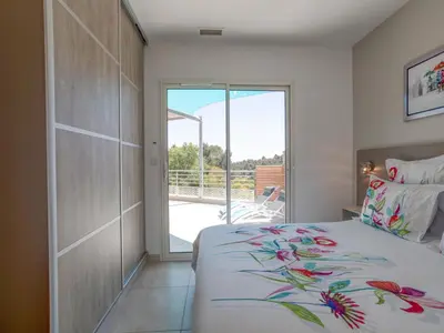 a bedroom with a bed and a sliding glass door at Luxury villa with private pool in Cesseras in Cesseras