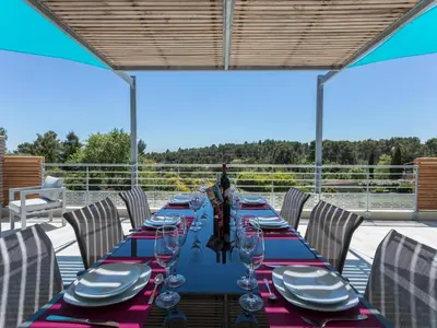 a long table with plates and wine glasses on a deck at Luxury villa with private pool in Cesseras in Cesseras