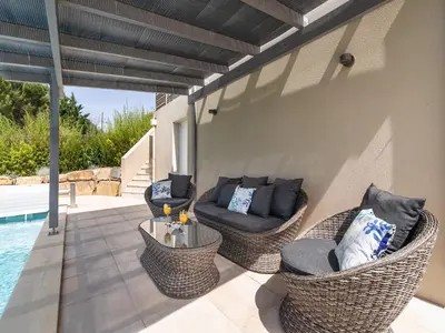 a patio with wicker chairs and a table next to a pool at Luxury villa with private pool in Cesseras in Cesseras