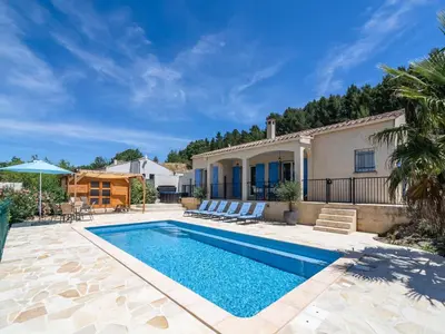 a swimming pool in front of a house at Wine Country Family Villa in Félines-Minervois