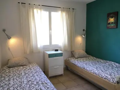 two beds in a room with a window at Wine Country Family Villa in Félines-Minervois