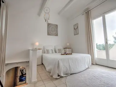 a white bedroom with a bed and a fireplace at Modern villa with private pool in Pouzols-Minervois