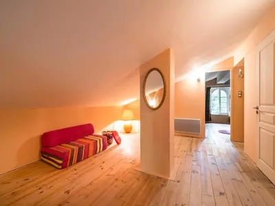 a living room with a red couch and a mirror at Stone House St Denis with Pool & Views in Saint-Denis