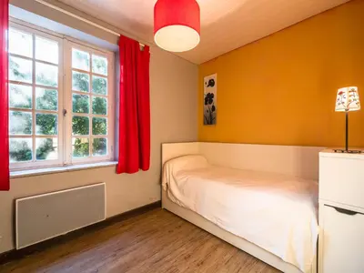 a bedroom with a bed and two windows at Stone House St Denis with Pool & Views in Saint-Denis