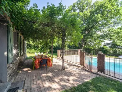 a patio with a table and chairs next to a pool at Stone House St Denis with Pool & Views in Saint-Denis