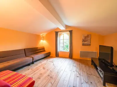 a living room with a couch and a television at Stone House St Denis with Pool & Views in Saint-Denis