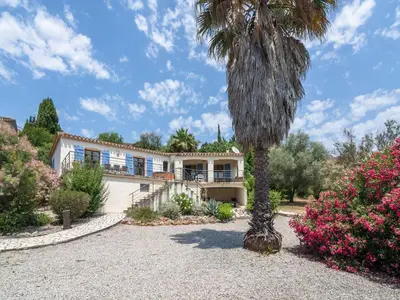 a palm tree in front of a house at Modern Villa with Heated Pool in Beaufort