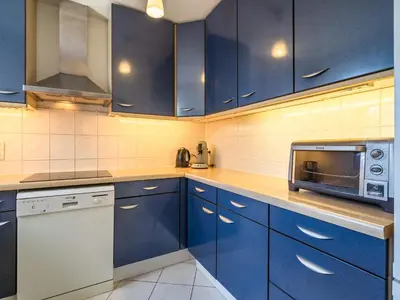 a kitchen with blue cabinets and a microwave at Modern Villa with Heated Pool in Beaufort