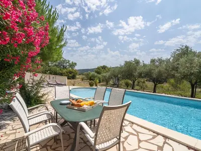 a patio with a table and chairs next to a swimming pool at Modern Villa with Heated Pool in Beaufort