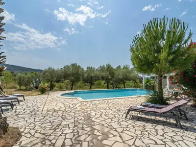 a swimming pool with two chairs and a tree at Modern Villa with Heated Pool in Beaufort