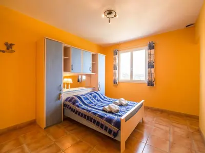 a bedroom with orange walls and a bed with teddy bears on it at Hillside Retreat in Roquebrun in Roquebrun