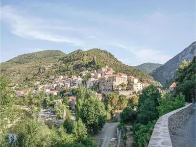 a small town on a mountain with a road at Hillside Retreat in Roquebrun in Roquebrun