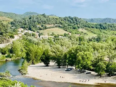 a group of people on a beach next to a river at Hillside Retreat in Roquebrun in Roquebrun