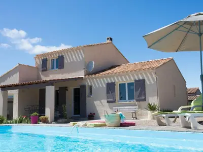 a villa with a swimming pool in front of a house at Villa in Beaufort with Private Pool in Beaufort