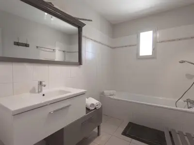 a white bathroom with a sink and a bath tub at Villa in Beaufort with Private Pool in Beaufort