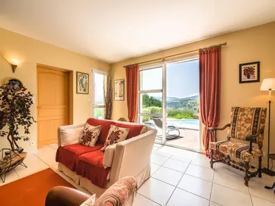 a living room with a couch and a large window at Villa in Limoux with Private Pool & Mountain Views in Limoux