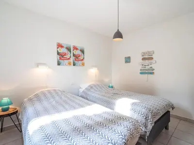 a bedroom with a bed with a blue comforter at Relaxing Villa Near Lake & Beaches in Beaufort