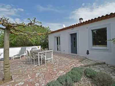 a patio with a table and chairs next to a house at Villa in Malves near Carcassonne Pool in Malves-en-Minervois