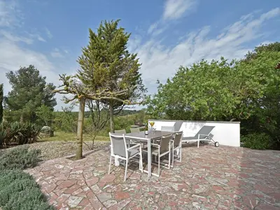 a patio with a table and chairs and a tree at Villa in Malves near Carcassonne Pool in Malves-en-Minervois