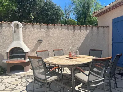 a patio with a table and chairs and a fireplace at Villa near Carcassonne with Heated Pool in Félines-Minervois