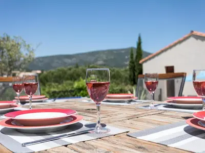 a wooden table with wine glasses and plates on it at Villa near Carcassonne with Heated Pool in Félines-Minervois