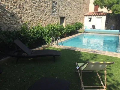 a yard with a pool and a chair and a table at Villa in Olonzac with Pool near Lac du Jouarres in Olonzac