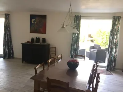 a dining room with a table and chairs and a large window at Villa in Olonzac with Pool near Lac du Jouarres in Olonzac