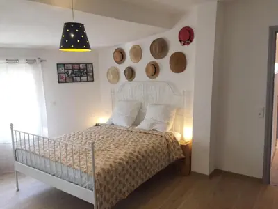 a bedroom with a white bed with a white headboard at Villa in Olonzac with Pool near Lac du Jouarres in Olonzac