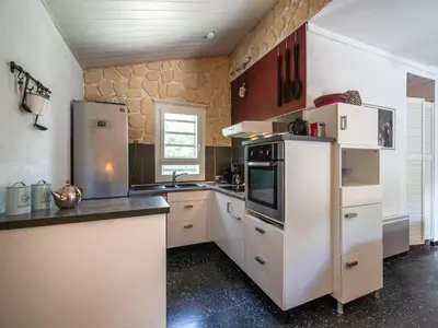 a kitchen with white cabinets and a refrigerator at Villa in Pouzols with Private Pool in Pouzols-Minervois