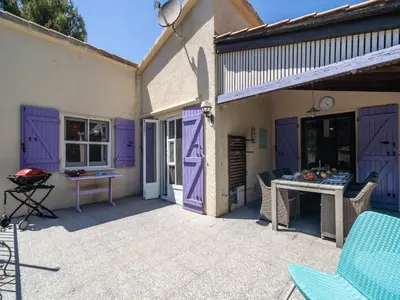 a patio with purple doors and a table and chairs at Villa in Pouzols with Private Pool in Pouzols-Minervois