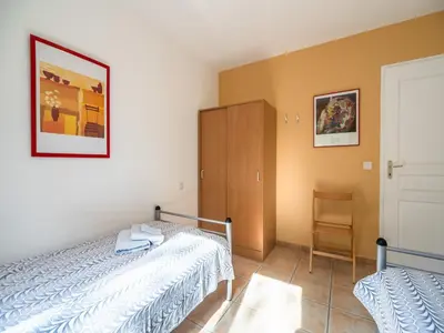 a bedroom with a bed and a cabinet and a chair at Spa Oasis Near Canal du Midi in Félines-Minervois