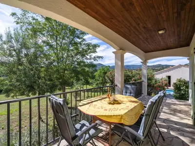 a patio with a table and chairs on a deck at Spa Oasis Near Canal du Midi in Félines-Minervois