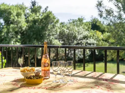 a bottle of champagne and two wine glasses on a table at Spa Oasis Near Canal du Midi in Félines-Minervois