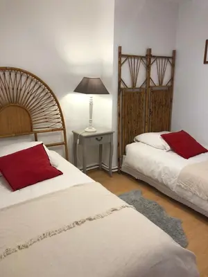 a bedroom with two beds and a table with a lamp at Côte de la Cité in Carcassonne