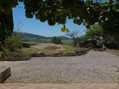 a gravel driveway with a stone wall and a field at Villa in Beaufort with Pool & Views in Beaufort