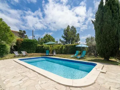 a pool in a yard with chairs and an umbrella at Villa in Beaufort with Pool & Views in Beaufort