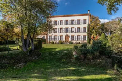 an exterior view of a large building with trees at Château du Pegulier in Montaut-Ariège