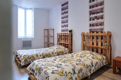two twin beds in a room with a window at Gîte proche du canal du midi et Narbonne 2 chambres in Mirepeisset